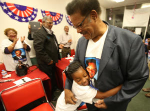 Richmond mayoral candidate Nat Bates, right, hugs supporter Cherish Lincoln, 7, left, during an election night party on Tuesday, Nov. 4, 2014, in Richmond,